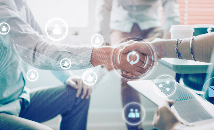 Two people shaking hands in a business setting, with digital network icons overlayed, suggesting a professional partnership, collaboration, or agreement. Another person is holding a tablet in the foreground.
