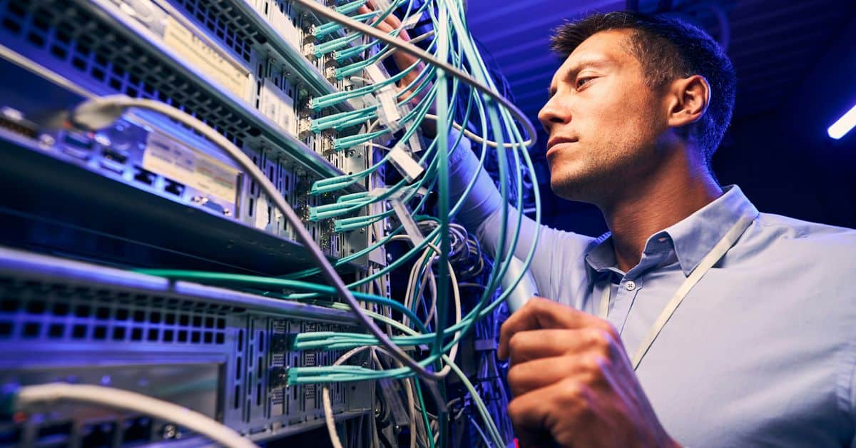 Cable certification verification Dallas technician using a Fluke tester on a commercial patch panel